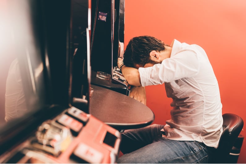 Despondent gambler at slot machine