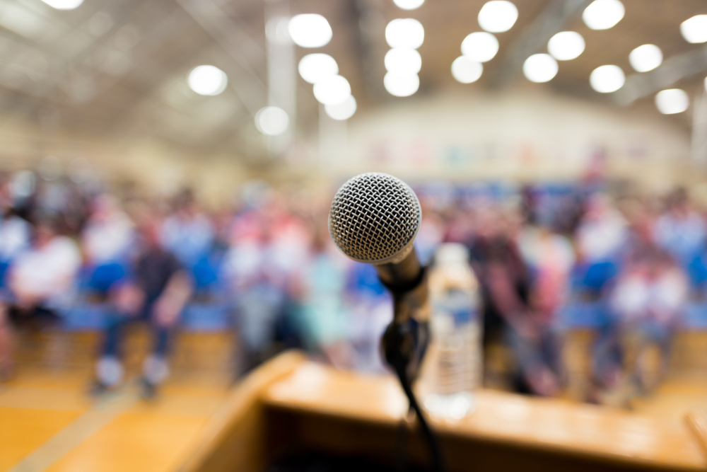 microphone on podium with audience in auditorium