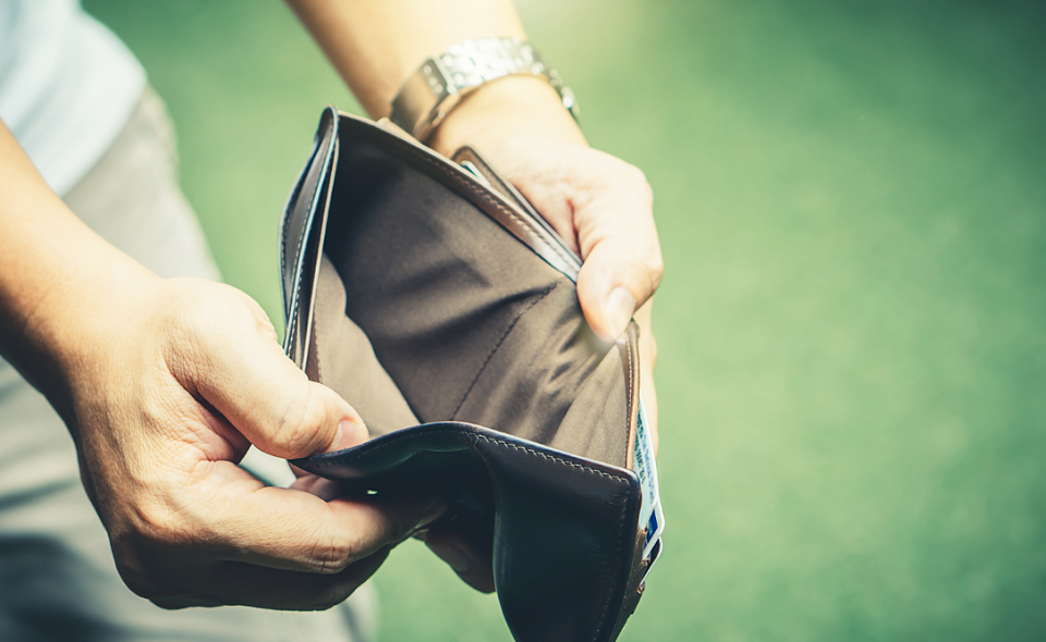 man holding empty black leather wallet