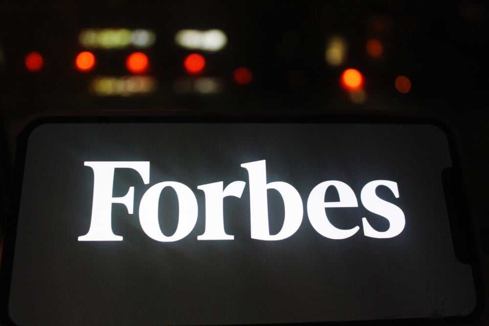 white Forbes logo displayed against a black background on a digital screen