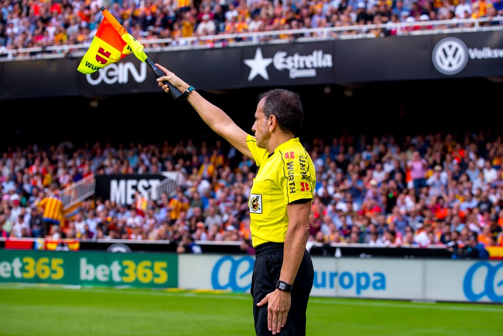 soccer referee raises flag