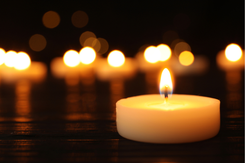 vigil candle with blurred candles in the background