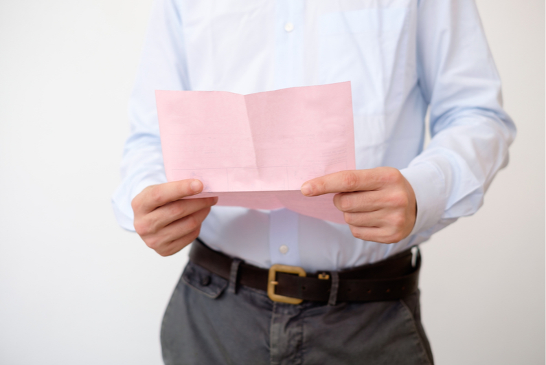 Man holding pink slip