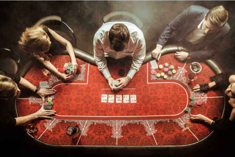 Top-down view of men and women playing poker