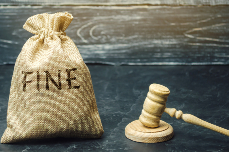 Judge's gavel next to a money bag labeled "FINE"